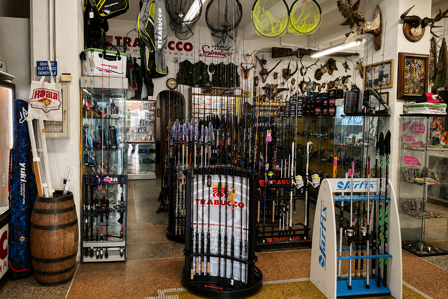 Reparto pesca: canne, mulinelli e accessori esposti in negozio
