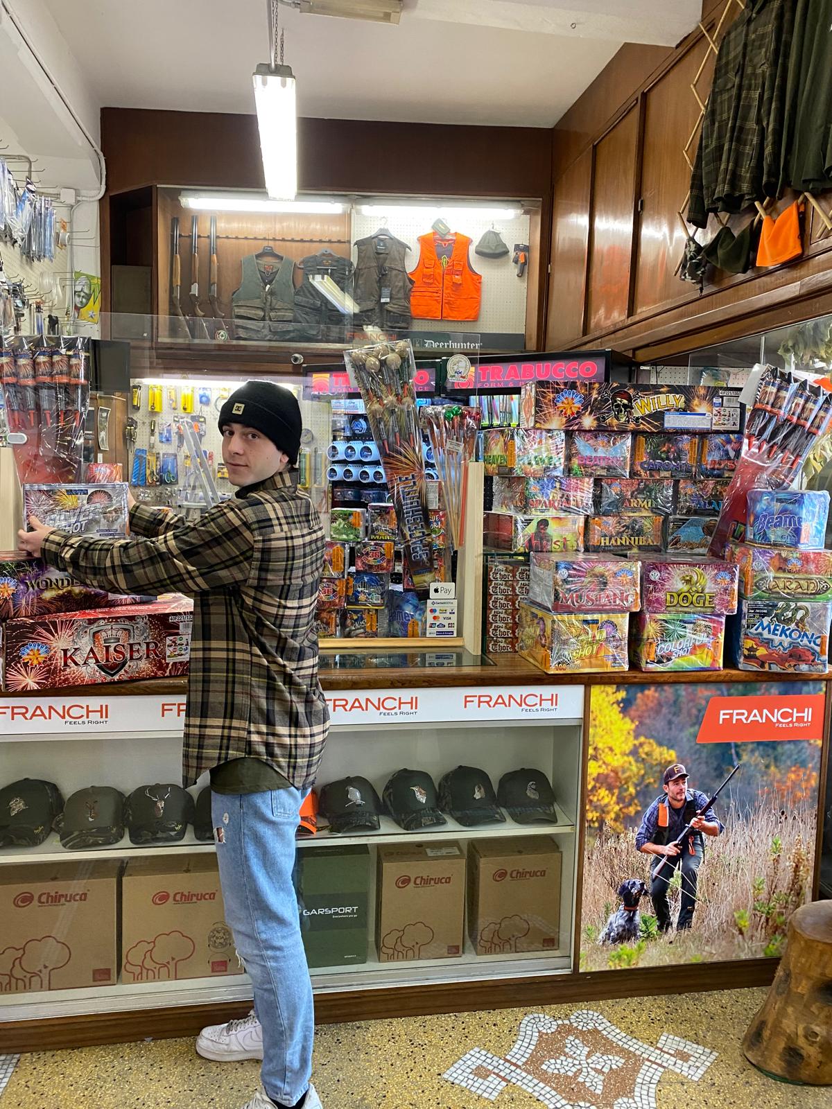Un ragazzo sistema i fuochi d’artificio sullo scaffale del reparto pirotecnica